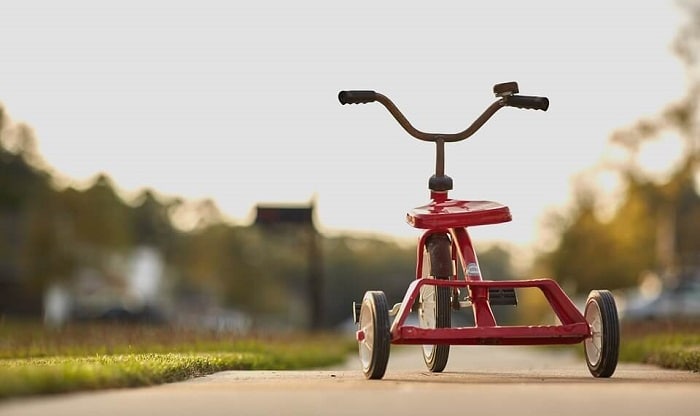 red tricycle on sidewalk at sunset