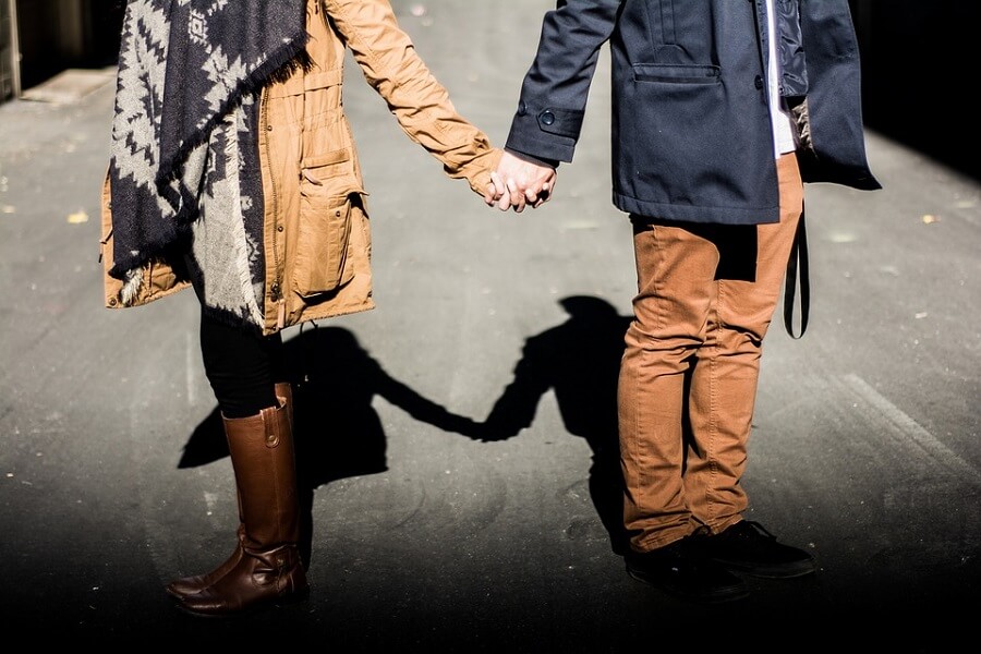 dressed up couple holding hands on street