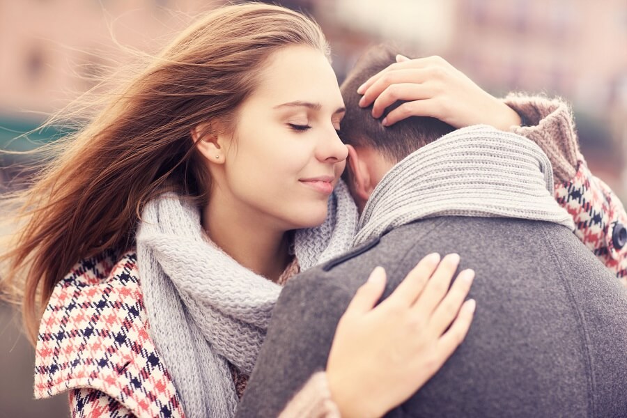 a woman hugging a man and smiling