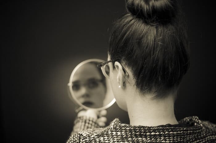 woman looking in the mirror for defects