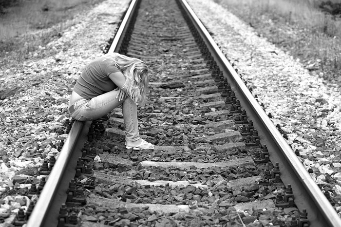 upset girl sitting on the rails