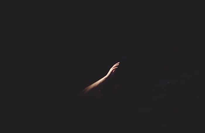 Picture of a hand reaching out through the darkness