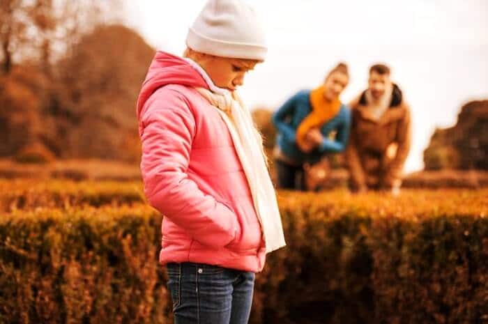 sad girl in park with parents