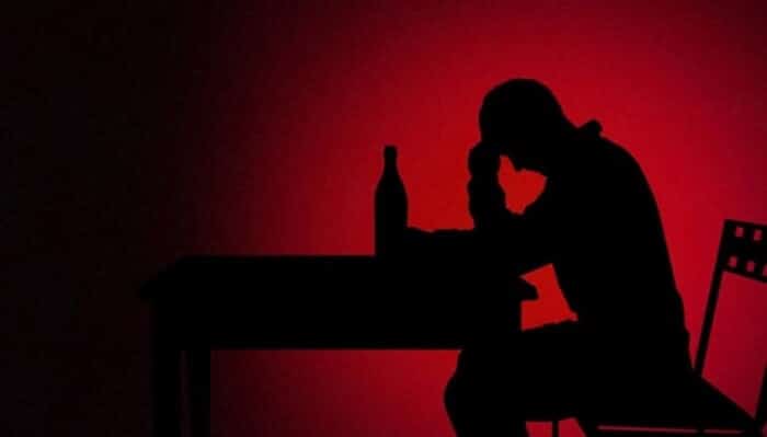 Alcoholic man silhouette against red background