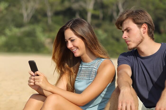 Jealous man looking at his girlfriend's texts