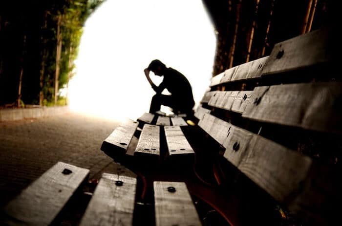 Depressed person sitting on a bench