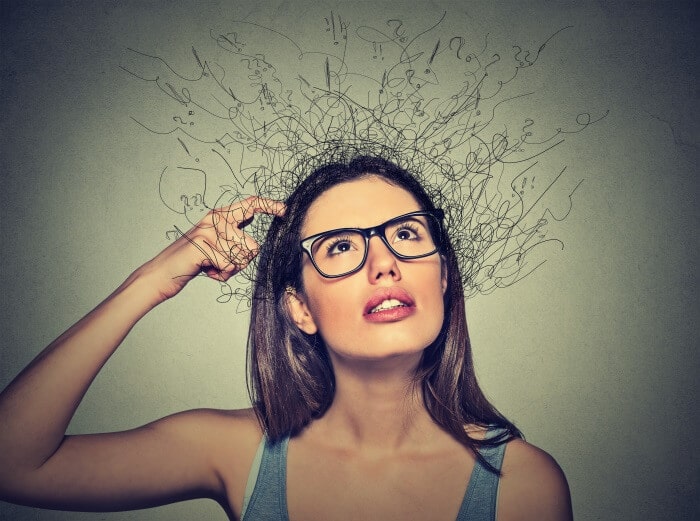 Girl with glasses scratching her head and looking up