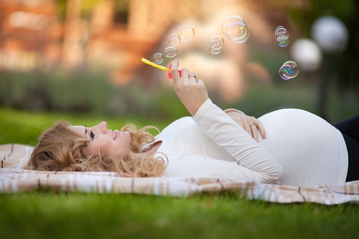 pregnant woman blowing bubbles