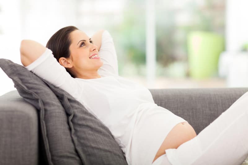 pregnant woman on the couch smiling