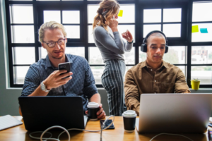 hawthorne effect: standing woman beside two men in front of laptop computer